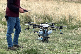 A staff member standing with the drone.