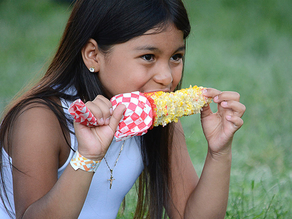 A girl eating corn on the cob. 