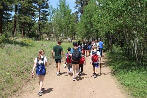 A group of young kids hiking along a natural trail