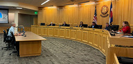 Jason Maxey sitting in front of the Weld County Board of Commissioners at a board meeting.