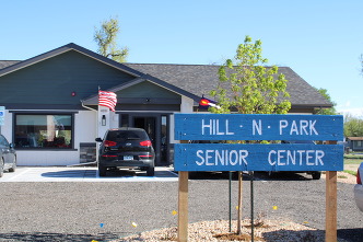 A sign reading "Hill N' Park Senior Center." The center is in the background.
