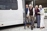 Older adults standing in front of a van.