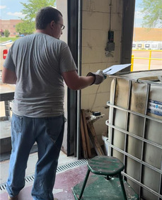 A Household Hazardous Waste staff member holding a clip board.