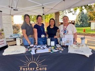 Weld County Foster Care staff standing behind a booth at Fiesta En La Plaza