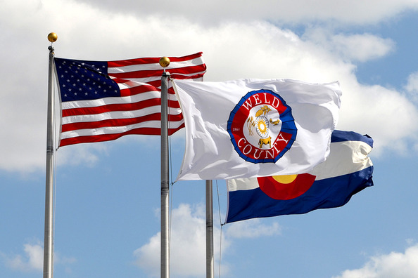 The county state and national flags outside the Weld County Administration Building.