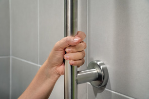 A hand grabbing a grab bar.