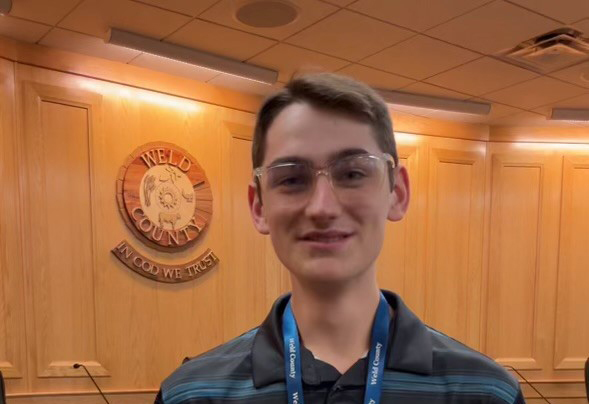 Jaeden Nelson standing in the Centennial Hearing Room of the Weld County Administration Building. 