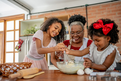 Grandma and granddaughters making Christmas cookies 