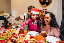A family laughing and enjoying dinner during the holidays.