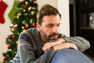 A person sitting on the couch looking sad during the holidays.