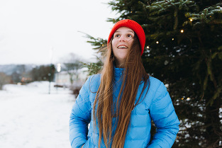 A girl in a coat, smiling.