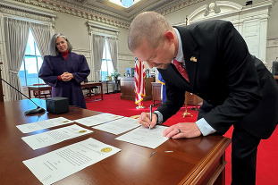 Jason Maxey signing paperwork on the day he was sworn in as a commissioner.