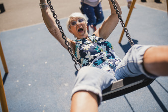 older woman happy on a swing set
