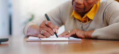 Closeup of senior man writing on a notepad