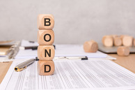 Blocks stacked on a piece of paper that spell "bond."