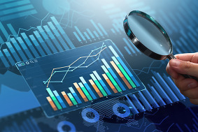 A magnifying glass looking at a chart of data. 