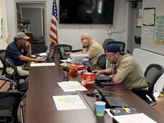 Three people sitting around a table during the Hurricane Helene response. 