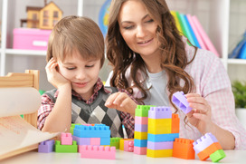 Woman and young boy playing with colorful blocks