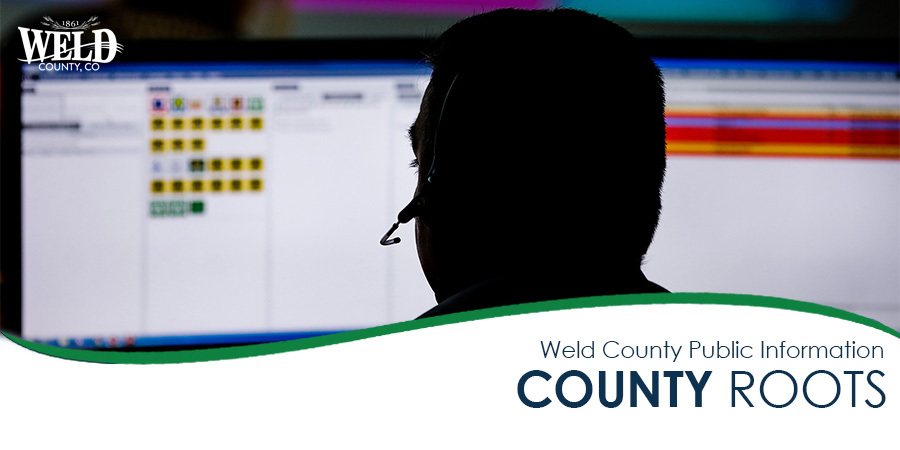 A shadow of a dispatcher in front of a computer screen. Weld County logo is in the top left.