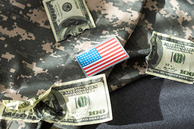 Military fatigues with dollar bills on them. A flag in the center.