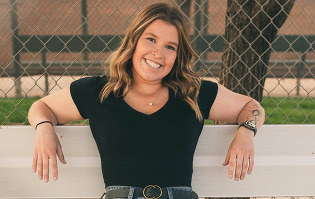 A girl, Kendree Kern, standing and smiling. 