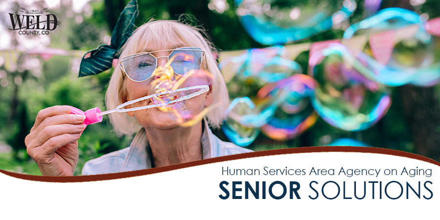Weld County Area Agency on Aging Senior Solutions newsletter header. An older woman blowing bubbles in the summer. 