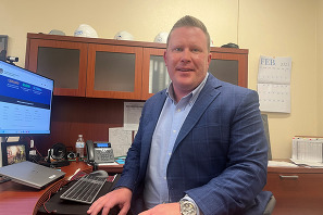 Brett Cavanagh sitting at his desk.
