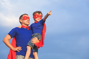 Father and son dressed as superheroes with masks and capes