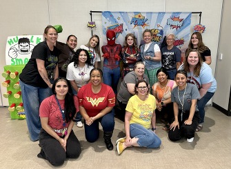 Reunification Event Planning Committee pose with superheroes at the event