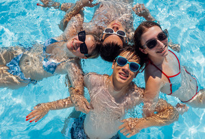 Teenagers locking arms in a swimming pool