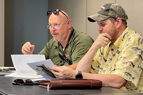 Dave Burns and Ben Atkins with the Weld County Office of Emergency Management look over documents during an operations briefing at the Stampede.