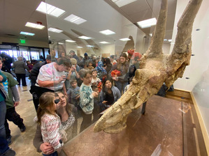 People looking at the display case housing Pops the Triceratops.