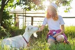Teen girl petting a goat