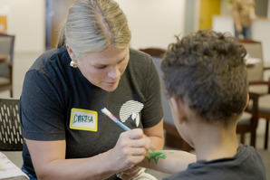 A boy getting a design painted on his arm.