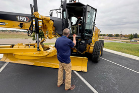 Weld County Public Works Director Curtis Hall talking to the operator of a motor grader at the Touch-a-Truck event. 