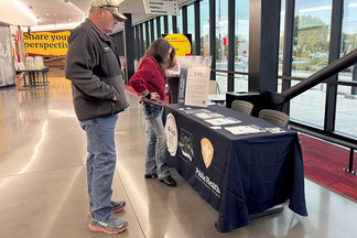 Attendees looking at information presented by the Weld County Department of Public Health and Environment. 