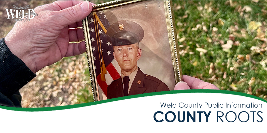 Wanda holding a framed portrait of Ron, age 21, when he enlisted in the Army