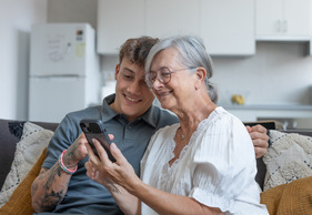 Grandson helping grandmother use cell phone