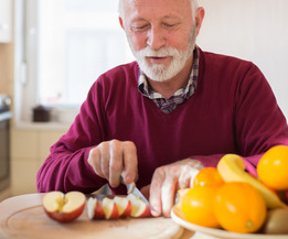 Senior man cutting an apple