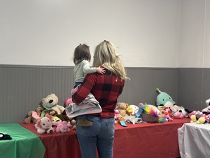 Mother and daughter browsing table of stuffed animals