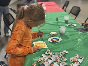 Young girl painting a wooden ornament craft