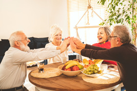 Group of older adults high fiving while enjoying a healthy snack
