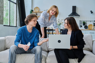 Mother and teenage boy working with a social worker at home