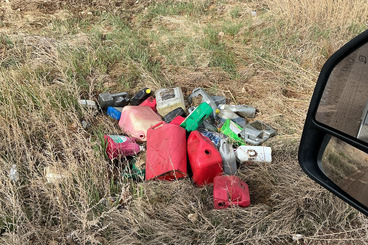 Trash and bottles near a county road.