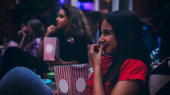 Girl watches a movie while eating popcorn