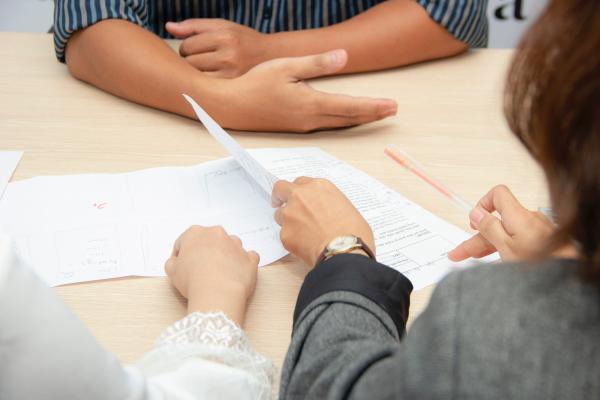 three sets of hands at a table with job application