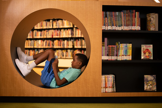 Young boy reading in a cubby