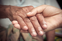 Image of Hand of Older Adult and Caregiver