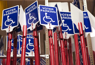 multiple signs say voter parking with the wheelchair symbol beneath