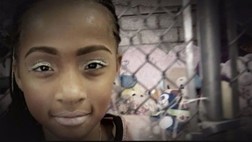 Stormiyah smiles at the camera. She has green sparkly eye shadow on. 